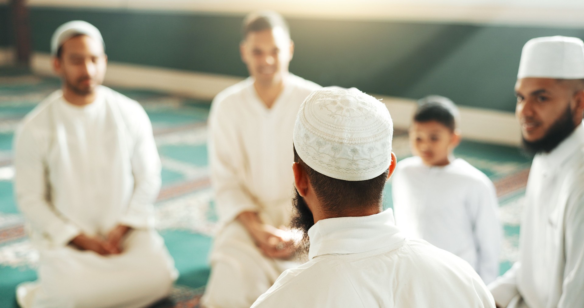 Islam, discussion and group of men in mosque with child, mindfulness and faith gratitude. Worship, religion and love, Muslim people together in holy temple for praise and spiritual teaching with boy.