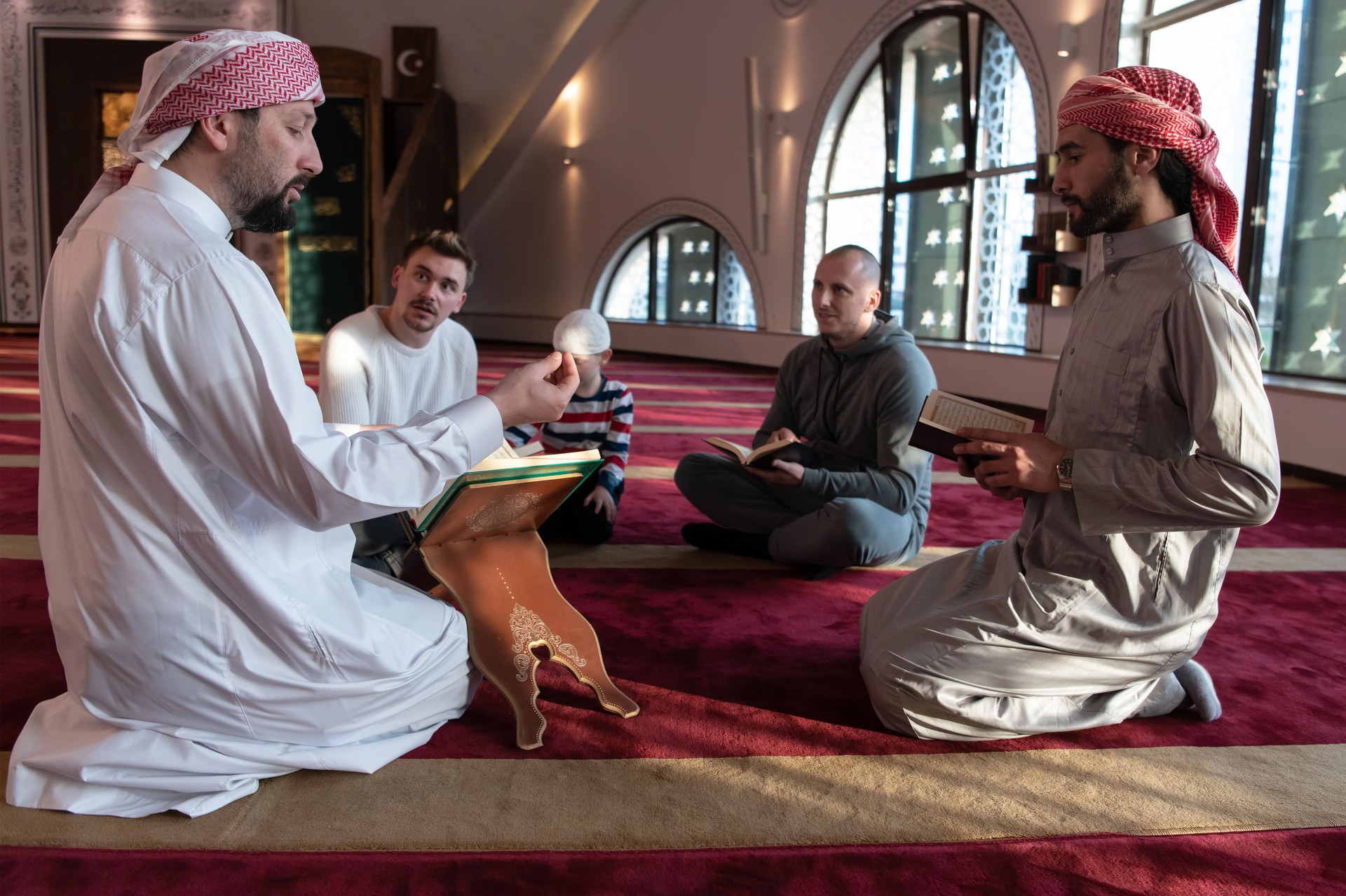 muslim people in mosque reading quran together