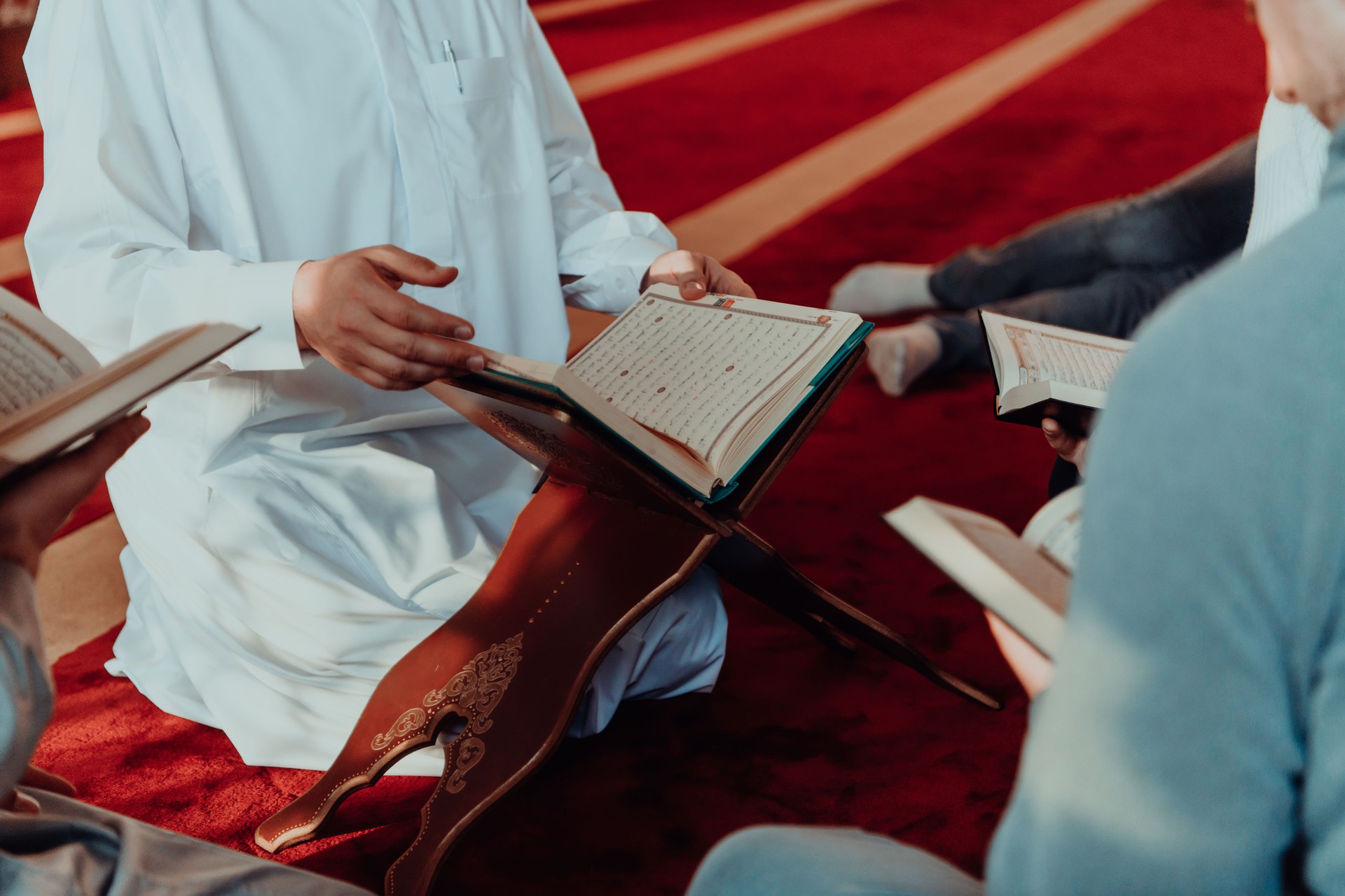 A group of Muslims reading the holy book of the Quran in a modern mosque during the Muslim holiday of Ramadan